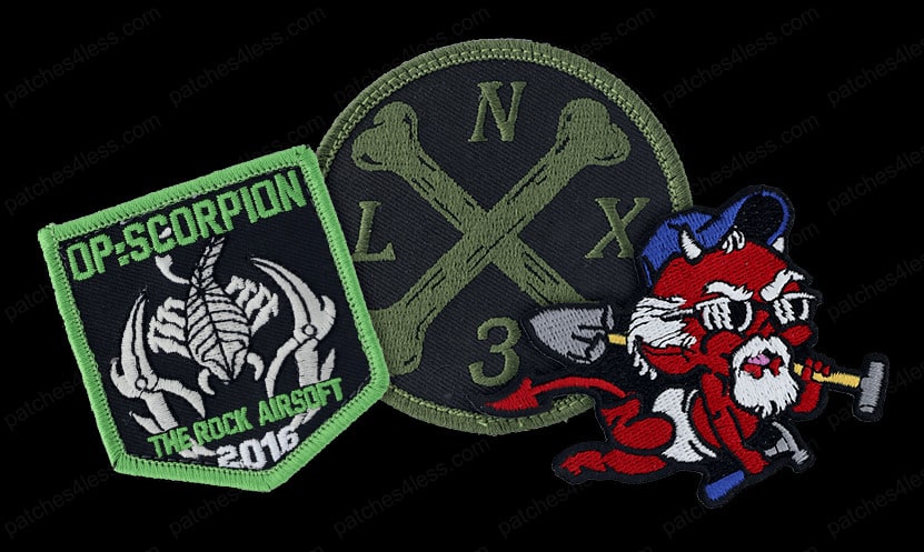 Three embroidered airsoft patches including a scorpion design labeled 'OP: SCORPION THE ROCK AIRSOFT 2016,' a circular patch with crossed bones and the letters 'LNX3,' and a cartoon devil character holding a sledgehammer and shovel