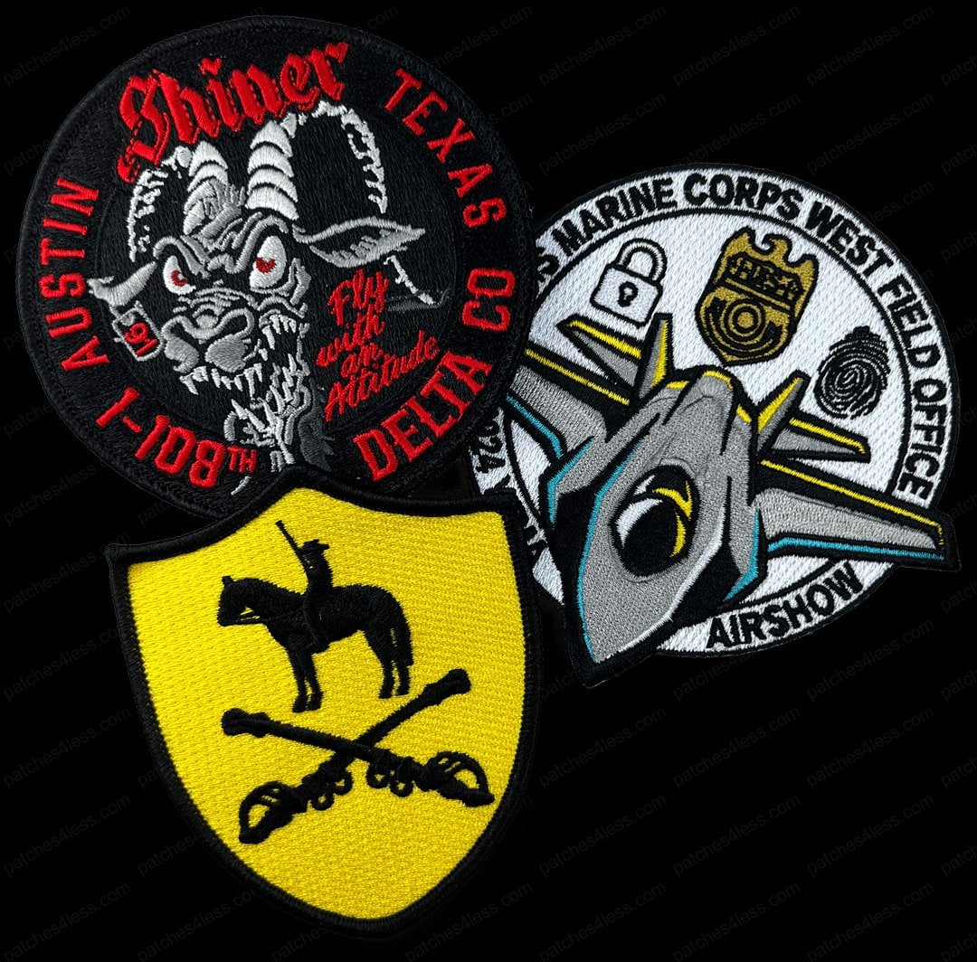 Three military patches. One is circular with a demonic goat and the text 'Shiner Texas I-108th Delta Co Fly with an Attitude', another features a yellow shield with a soldier on horseback and crossed sabers, and the third shows a jet with the text 'US Marine Corps West Field Office Airshow'.