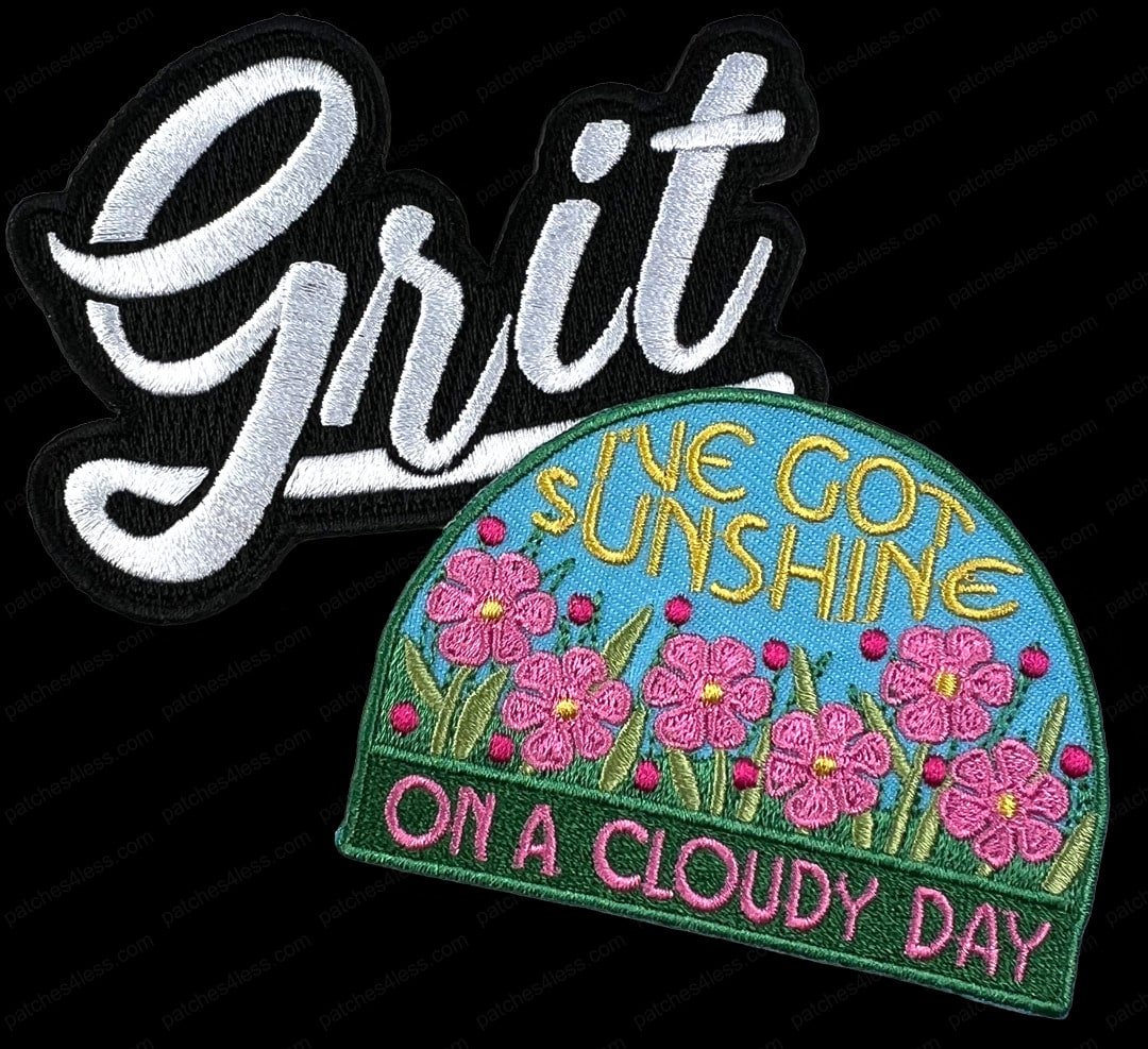 Two motivational patches. One has the word 'Grit' in white cursive on a black background. The other features pink flowers and the text 'I've Got Sunshine on a Cloudy Day'.