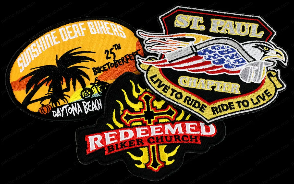 Three embroidered biker patches, including “Sunshine Deaf Bikers” with a sunset and palm tree, “St. Paul Chapter” featuring an eagle and American flag, and “Redeemed Biker Church” with a flaming cross design.