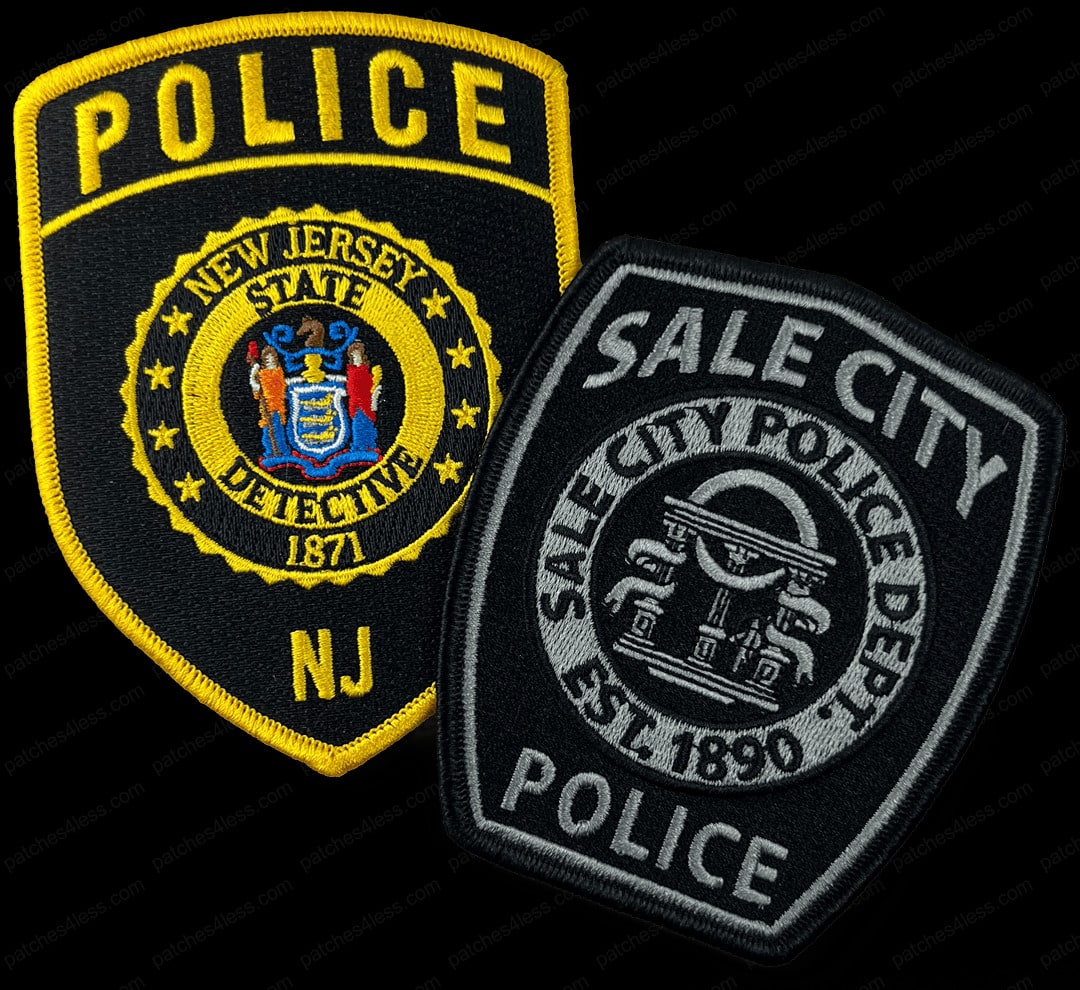 Two police patches. One is a yellow and black patch with the New Jersey State emblem and the text 'New Jersey State Detective 1871 NJ'. The other is a black and gray patch with the text 'Sale City Police Dept. Est. 1890 Police'.